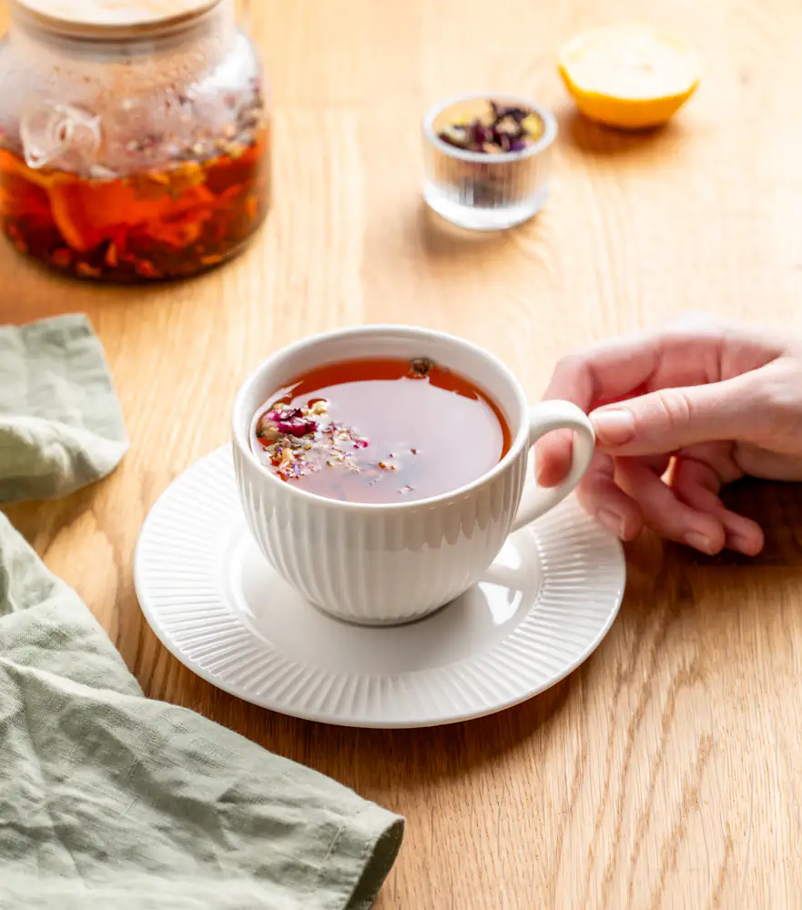 hand holding a cup of rooibos herbal tea