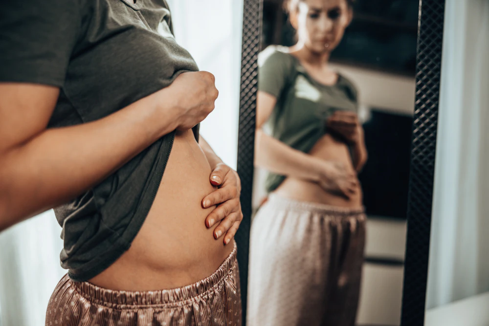 Woman holding bloated belly